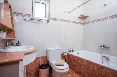 a bathroom with a toilet and a sink and a tub at Christina's House in Afantou