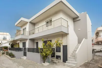 a white house with a balcony at Christina's House in Afantou