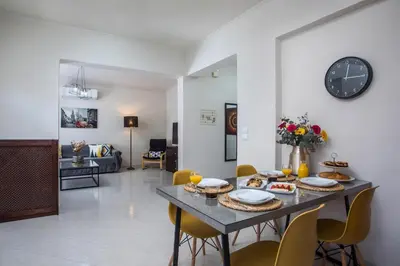 a dining room with a table with chairs and a clock at Christina's House in Afantou