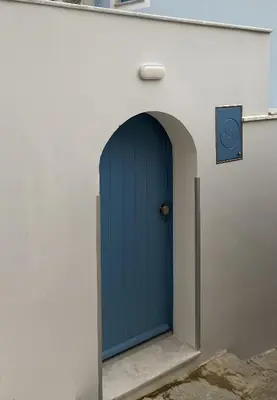 a blue door in the side of a building at Aleminas Rooms 1 in Symi