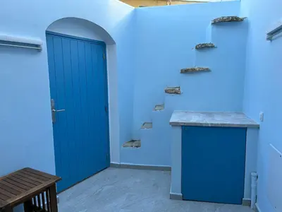 a blue door in a room with a bench at Aleminas Rooms 1 in Symi