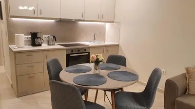 a kitchen with a table and chairs in a kitchen at Ma Maison Bleue in Kremasti