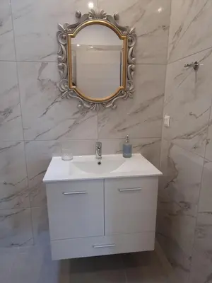 a bathroom with a white sink and a mirror at Ma Maison Bleue in Kremasti