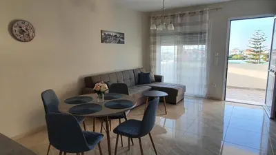 a living room with a couch and a table and chairs at Ma Maison Bleue in Kremasti