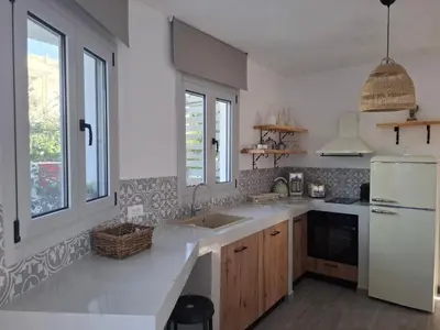 a kitchen with a sink and a white refrigerator at Rhodes Soul Luxury Suites in Afantou