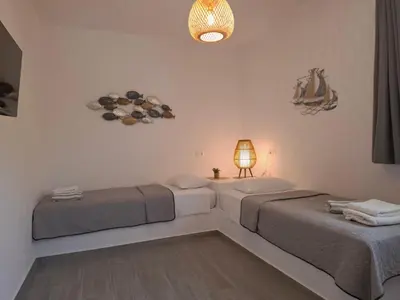 two beds in a room with a lamp and a lightswitch at Rhodes Soul Luxury Suites in Afantou
