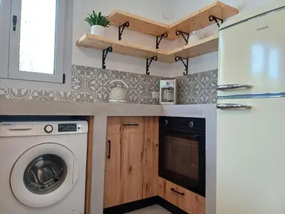 a kitchen with a washing machine and a refrigerator at Rhodes Soul Luxury Suites in Afantou