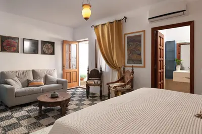 a bedroom with a bed and a couch and a table at Villa Venetoklis in Líndos