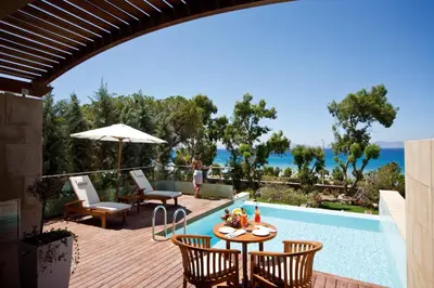 a patio with a table and chairs next to a swimming pool at Amus Hotel & Spa in Ixia