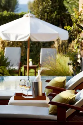 a table with a glass of wine and an umbrella at Amus Hotel & Spa in Ixia