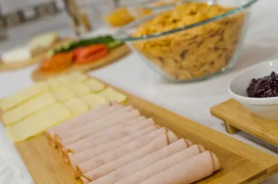 a cutting board with ham and cheese on a table at Diana Art Boutique Hotel in Rhodes Town