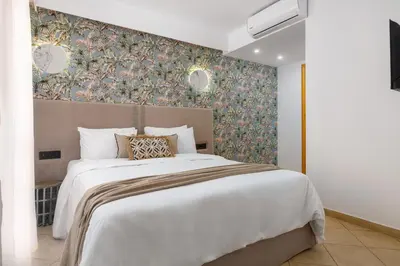 a bedroom with a large white bed with a floral wallpaper at Diana Art Boutique Hotel in Rhodes Town