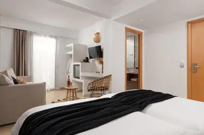 a white bedroom with a bed and a chair at Diana Art Boutique Hotel in Rhodes Town