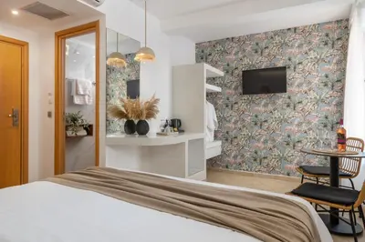 a bedroom with a bed and a tv on a wall at Diana Art Boutique Hotel in Rhodes Town