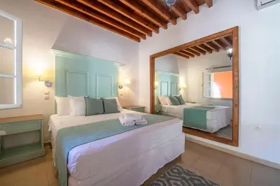 a bedroom with two beds and a mirror at Saint Artemios Boutique Hotel in Rhodes Town