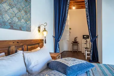 a bedroom with a bed and blue curtains at Saint Artemios Boutique Hotel in Rhodes Town