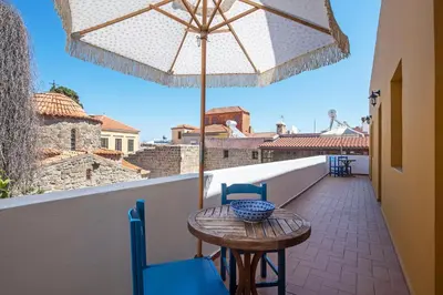 a table and chairs on a balcony with an umbrella at Saint Artemios Boutique Hotel in Rhodes Town