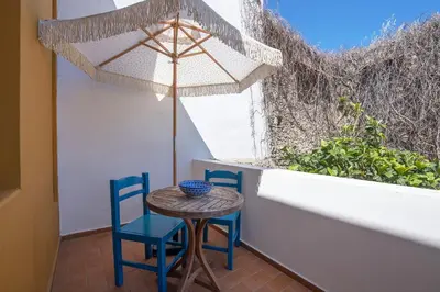 a table and two chairs and an umbrella on a balcony at Saint Artemios Boutique Hotel in Rhodes Town