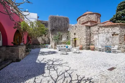 a courtyard of a stone building with tables and chairs at Saint Artemios Boutique Hotel in Rhodes Town
