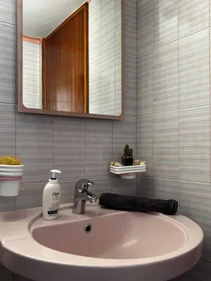 a bathroom sink with a mirror and a bottle of soap at Dim Domus _ Apolakkia, South Rhodes in Apolakkiá