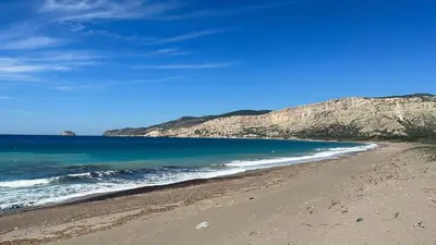 a beach with the ocean and mountains in the background at Dim Domus _ Apolakkia, South Rhodes in Apolakkiá
