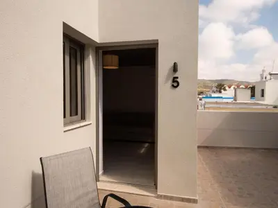 a door to a balcony with a table and a chair at STARI in Kattavía