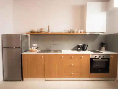 a kitchen with wooden cabinets and a stainless steel refrigerator at STARI in Kattavía