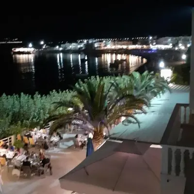 a palm tree on a patio at night at Artoria Apartment 2 First Floor in Haraki