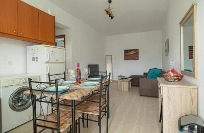 a kitchen and living room with a table and chairs at Basiliki's Apartments in Archangelos