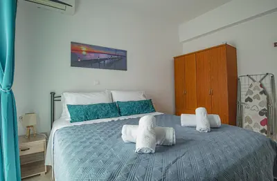 a bedroom with a bed with towels on it at Basiliki's Apartments in Archangelos