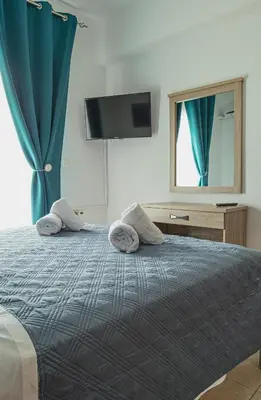 a bedroom with a bed with towels on it at Basiliki's Apartments in Archangelos