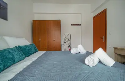 a bedroom with a bed with towels on it at Basiliki's Apartments in Archangelos