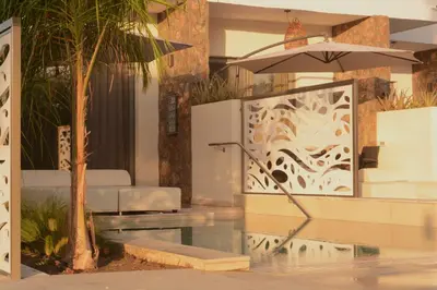 a hotel lobby with a table and an umbrella at Anemone Premium Suites Faliraki in Faliraki