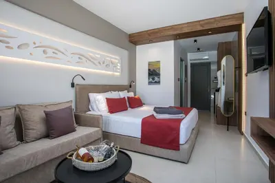 a hotel room with a bed and a couch at Anemone Premium Suites Faliraki in Faliraki