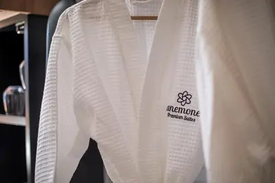 a white sweater with a logo on it on a shelf at Anemone Premium Suites Faliraki in Faliraki
