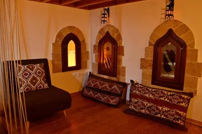 a living room with a chair and a mirror at The three story old town house in Rhodes Town