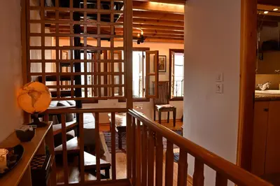 a living room with a staircase and a dining room at The three story old town house in Rhodes Town