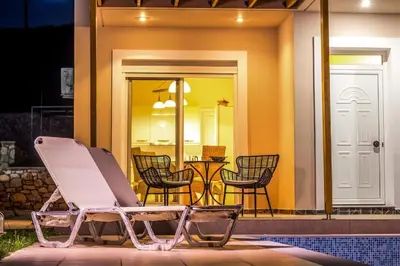 a chair sitting in front of a house at Villa Regina - Double Pool Paradise in Lachania