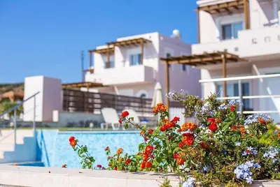 a swimming pool with flowers in front of a house at Villa Regina - Double Pool Paradise in Lachania