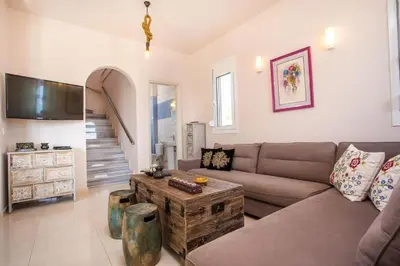 a living room with a couch and a table at Villa Regina - Double Pool Paradise in Lachania