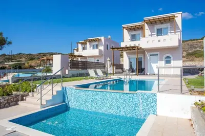 a villa with a swimming pool in front of a house at Regina Villa - Family Dream with double pool in Lachania