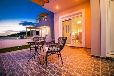 a patio with chairs and a table on a house at Regina Villa - Family Dream with double pool in Lachania
