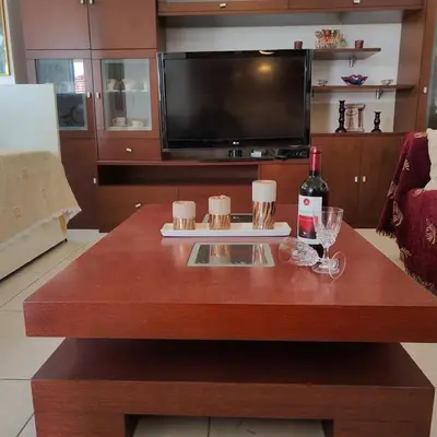 a wooden table with a bottle of wine and a television at Evaggelia's Private House in Fanes Rhodes in Phanaes