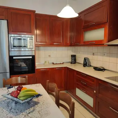 a kitchen with wooden cabinets and a table with fruit on it at Evaggelia's Private House in Fanes Rhodes in Phanaes