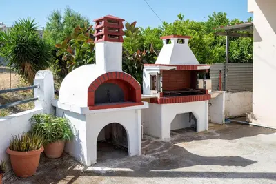 a small pizza oven sitting next to a house at Evaggelia's Private House in Fanes Rhodes in Phanaes