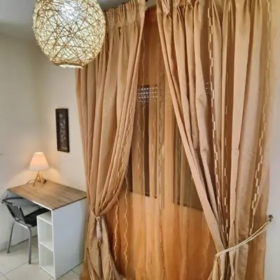 a curtain in a room with a desk and a lamp at Evaggelia's Private House in Fanes Rhodes in Phanaes