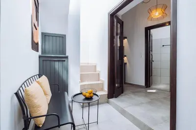 a hallway with a table and a chair and a mirror at Kilistra Lindian Living in Líndos