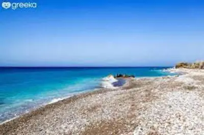 a beach with blue water and a rocky shore at Casa d'oro 56 Living in Paradisi Rhodes in Paradeísion