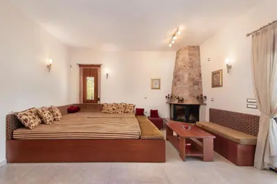 a bedroom with a large bed and a fireplace at Vlasis' Eden Villa - Islander's Home Collection in Sálakos