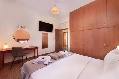 a bedroom with a bed with a desk and a mirror at Vlasis' Eden Villa - Islander's Home Collection in Sálakos